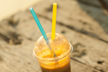Fresh juice in a plastic cup with two straws
