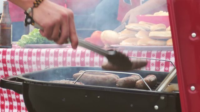 Tailgate: Close Up Of Man Cooking Sausage And Burgers