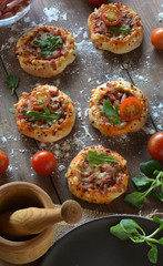 Rustic table with mini pizzas of bacon