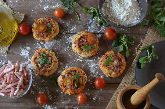 Rustic table with mini pizzas of bacon