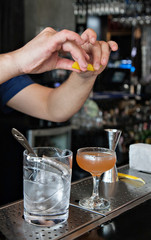 Bartender  squeezes zest