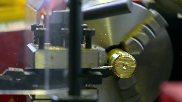 Lathe machine in action, super slow motion. Machining brass piece 250 fps close up shot