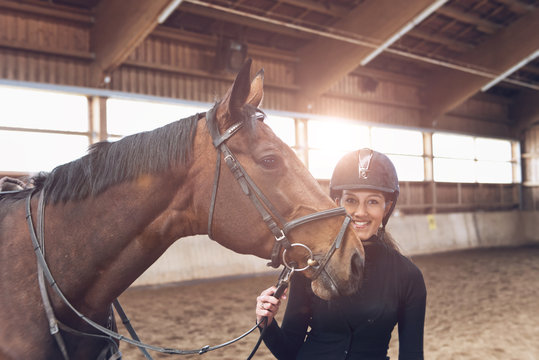 Smiling attractive woman with her horse