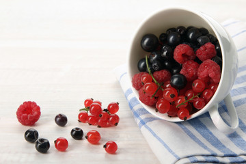 scattered  berries from a Cup on wooden background