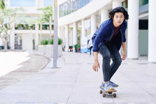 Vietnamese Young Guy Skateboarding In The City