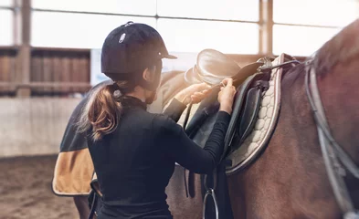 Küchenrückwand glas motiv Woman rider adjusting her stirrups on her saddle © XtravaganT