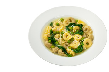 Tortellini Soup with Peas and Spinach Isolated. Selective focus.