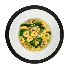 Tortellini Soup with Peas and Spinach Isolated. Selective focus.