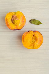 Ripe peaches on white wooden background