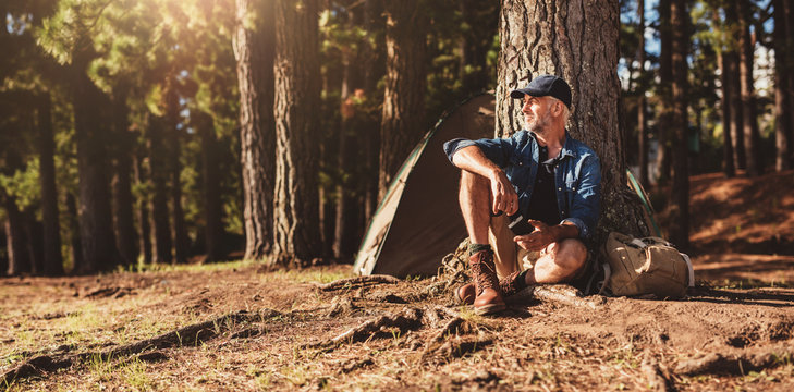 Mature man sitting at a campsite