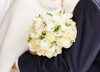 closeup of bride hands holding beautiful winter wedding bouquet