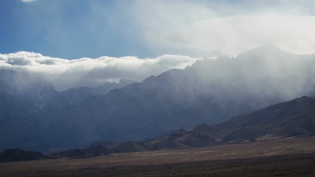 Time Lapse of  clouds over a desert mountain range.