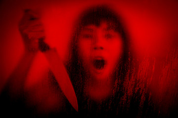 Horror scene of woman with knife behind stained or dirty window glass,Serial killer or violence...