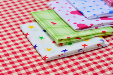 Stack of Multicolor napkin with checkered fabric on the tableware