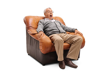 Scared senior sitting on an armchair
