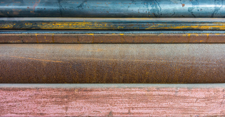 Texture of rusty metals. The surface of round steel pipes and light channel irons.