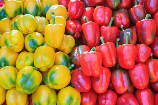 Yellow and red bell pepers close up in background