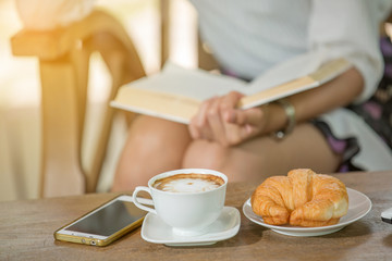 asian woman drink coffee and reading book in garden