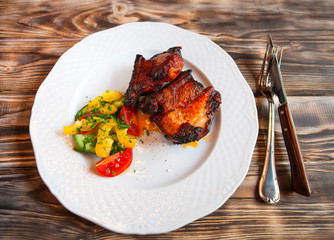 Pork meat grilled with fresh vegetable salad on a white plate. t