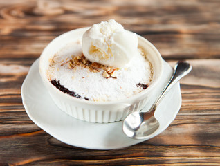 Tasty dessert with an ice cream ball on a wooden background