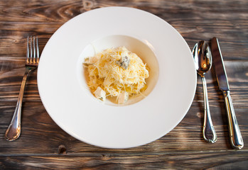 Tasty Italian paste with parmesan on a dark wooden background