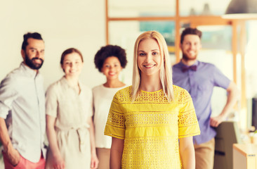 happy young woman over creative team in office