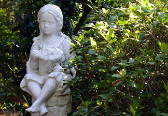 Statue of a little girl in a botanical garden