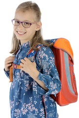 Schulkind mit Schulranzen geht zur Schule und lächelt 