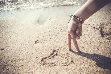 conceptual pictures - hand in the form of man on the beach at sunrise