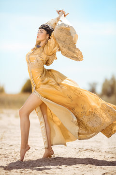 Beautiful woman like Egyptian Queen Cleopatra on in desert outdoor.