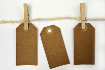 White background with sisal rope and clothes pins with empty copy space tags
