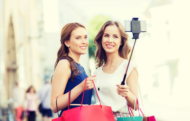 happy women with shopping bags and smartphone