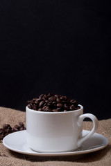 Coffee beans and coffee in cup on burlap. Selective focus
