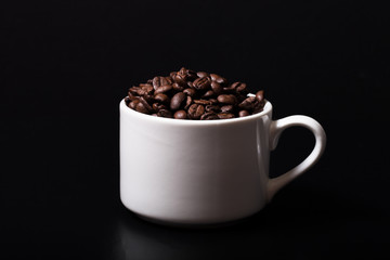 Coffee beans in the cup on black background