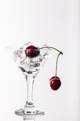 Cherry berries in a martini glass on white background