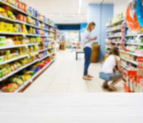 Wooden empty table in front of blurred supermarket