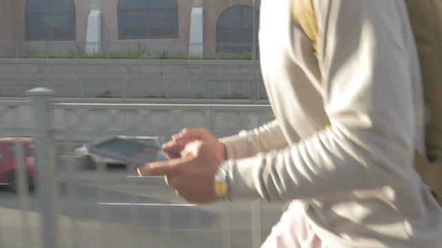 young guy in town on a skateboard with a tablet in hand in the summer