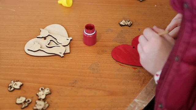 Craft and maker class, child coloring wooden heart, hobby, handmade course