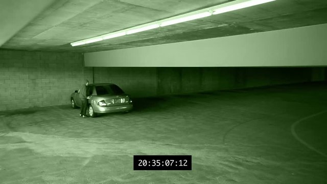 Security camera footage of a car being broken into.