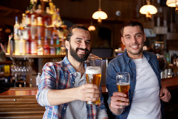 happy male friends drinking beer at bar or pub