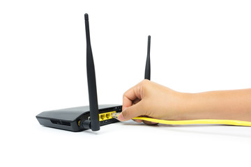 Hand connecting yellow cable to network device