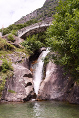 Fototapeta na wymiar Santa Petronilla waterfalls with roman bridge in Biasca