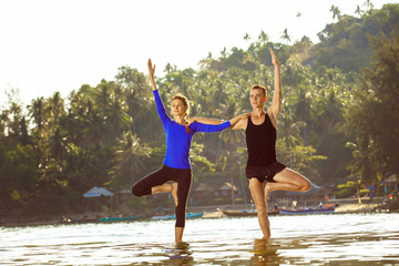 Fototapeta na wymiar Fitness, sport, and lifestyle concept - couple is exercising yoga