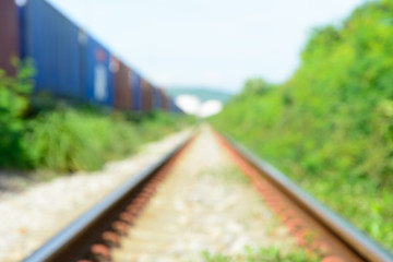 Blur background of railway track with cargo and green grass