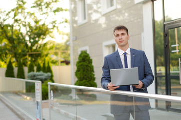 Fototapeta premium Case in a way. Confident and successful businessman holding a laptop.