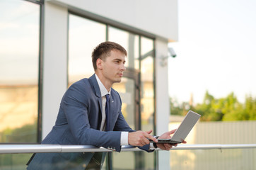 Fototapeta premium Case in a way. Confident and successful businessman holding a laptop.