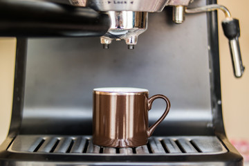 espresso machine making coffee and pouring in a brown  cup