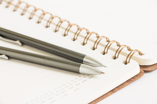 Calendar notebook with pen and pencil, selective focus