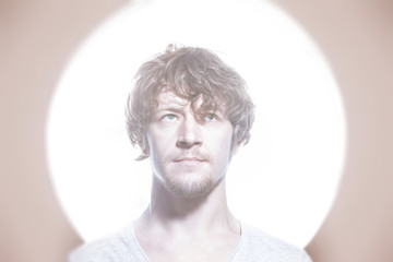 Closeup portrait of young creative man at bright circle light