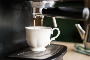 espresso machine making coffee and pouring in a white  cup